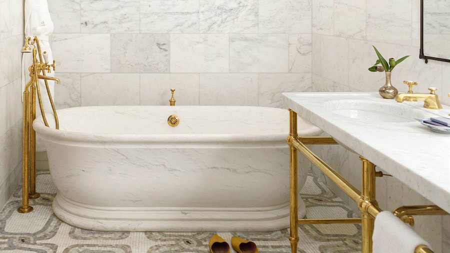 Elegant remodeled bathroom with marble tiles and brass fixtures