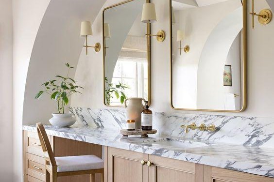 Remodeled bathroom with marble counter and brass fixtures
